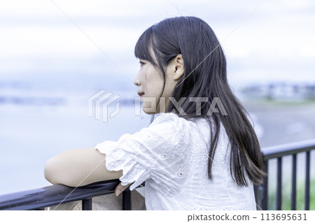 Profile of a woman looking at the sea 113695631