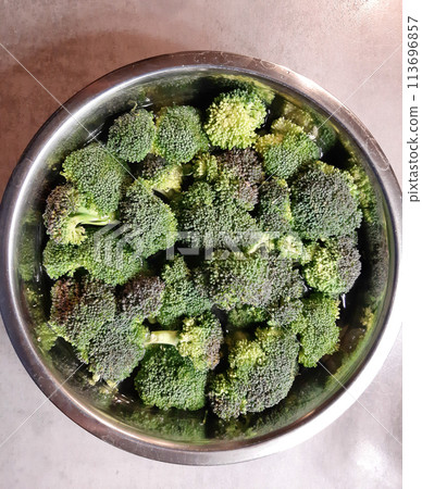 Raw broccoli chopped on a metal bowl. Healthy vegetables. 113696857