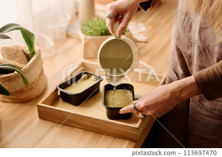 Woman pouring water in container Woman pouring water in container 113697470
