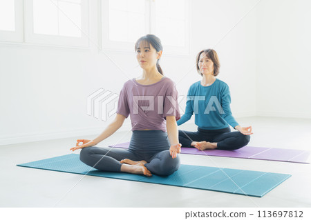 Woman practicing yoga in a yoga studio 113697812