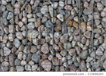 Pattern of many pebble stones behind a metal mesh as a fence design. Pattern of many pebble stones behind a metal mesh as a fence design. 113698263