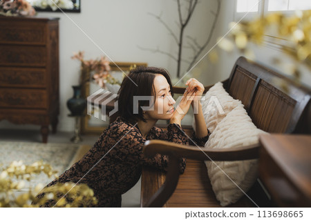 中年婦女坐在房間的沙發上 113698665