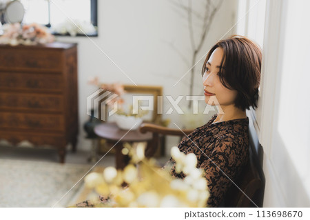 Middle-aged woman sitting on a sofa in a room 113698670