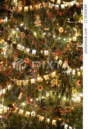 Brightly and beautifully decorated with flags and nutcracker toys huge retro style christmas tree. Close view. Saint Petersburg, Russia, 06.01.2021 Brightly and beautifully decorated with flags and nutcracker toys huge retro style christmas tree. Close view. Saint Petersburg, Russia, 06.01.2021 113698694