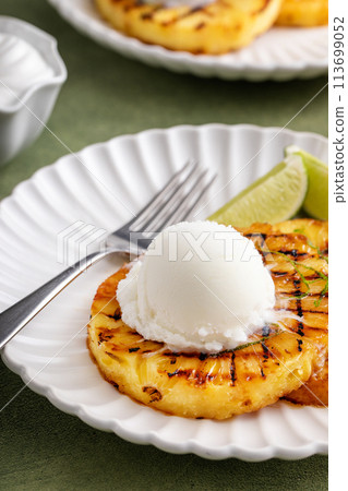 Grilled pineapple with lime honey glaze and whipped cream Grilled pineapple with lime honey glaze and whipped cream 113699052