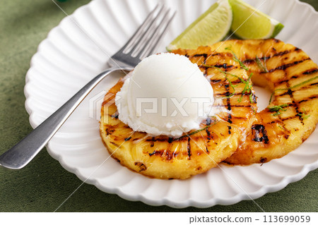 Grilled pineapple with lime honey glaze and whipped cream Grilled pineapple with lime honey glaze and whipped cream 113699059