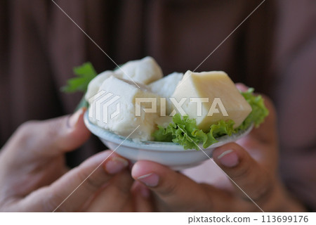 Food plate of cheese cubes and lettuce on checkered tablecloth 113699176