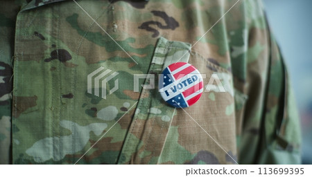 Military man puts on badge with American flag logo and inscription I Voted 113699395