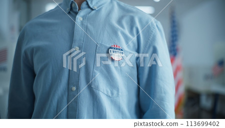 Businessman puts on badge with American flag logo and inscription I Voted Businessman puts on badge with American flag logo and inscription I Voted 113699402
