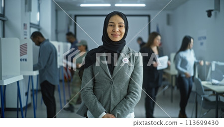Woman stands in a modern polling station, poses, smiles Woman stands in a modern polling station, poses, smiles 113699430