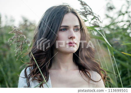 Glorious healthy young brunette woman with fresh clear skin and long dark brown hair outdoors  113699501
