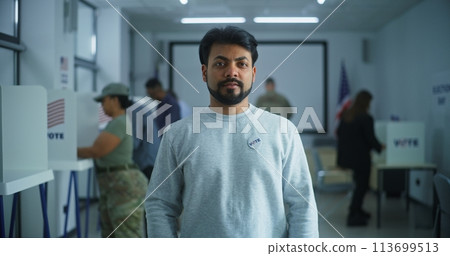 Indian man stands in a modern polling station and poses 113699513