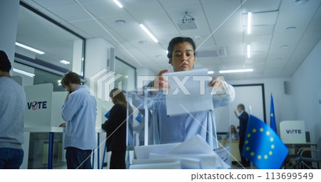 Caucasian male voter puts ballot paper in box during EU elections Caucasian male voter puts ballot paper in box during EU elections 113699549