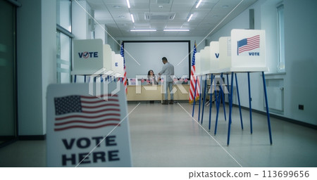 African American male voter walks to female polling officer at polling station 113699656