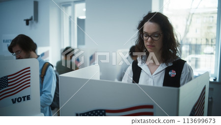 National Election Day in United States. Woman votes in booth 113699673