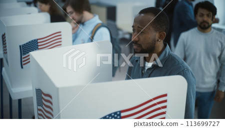 Multi ethnic American citizens vote in booths in polling station Multi ethnic American citizens vote in booths in polling station 113699727