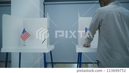 Dolly shot of diverse American citizens voting in booths in polling station office Dolly shot of diverse American citizens voting in booths in polling station office 113699752