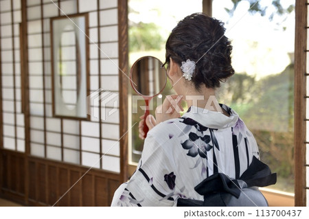 Back view of a young woman wearing a yukata 113700437