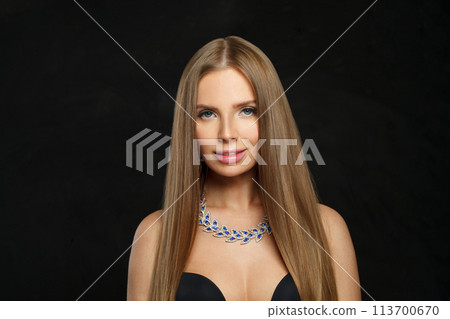 Stylish woman with makeup wearing jewelry necklace with sapphire and diamond on black background 113700670