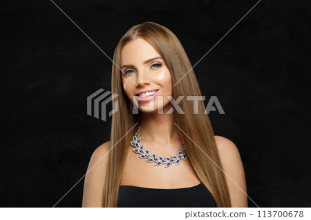 Charming woman with makeup wearing jewelry necklace with sapphire and diamond on black background Charming woman with makeup wearing jewelry necklace with sapphire and diamond on black background 113700678