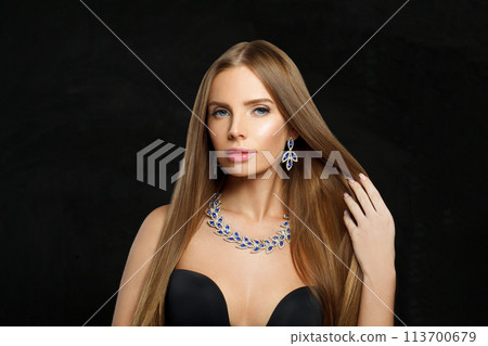 Gorgeous woman with makeup wearing jewelry necklace with sapphire and diamond on black background Gorgeous woman with makeup wearing jewelry necklace with sapphire and diamond on black background 113700679