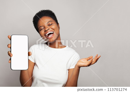 Cheerful woman showing smartphone with empty blank screen display. Model in white t-shirt with phone Cheerful woman showing smartphone with empty blank screen display. Model in white t-shirt with phone 113701274