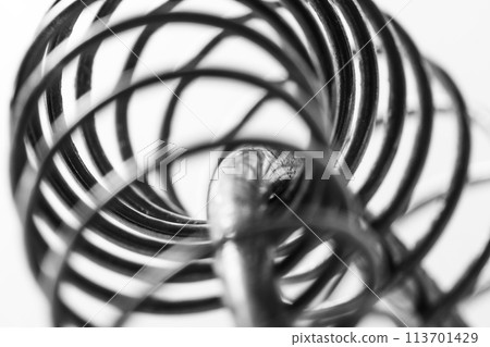 Metal spring coiled, black and white macro shot 113701429