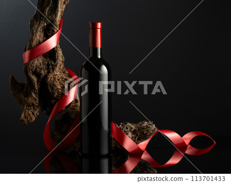 Bottle of red wine on a black reflective background. 113701433