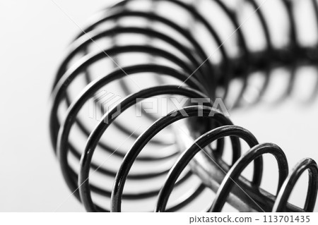 Metal spring coiled, black and white macro shot 113701435