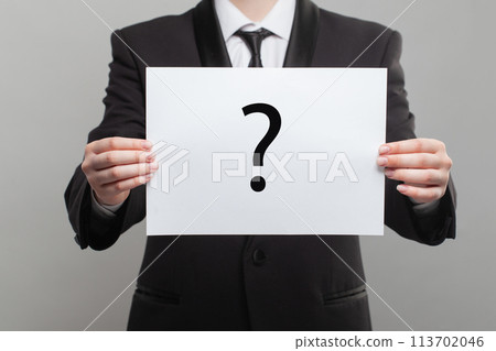 Black question mark on on white paper in hand 113702046