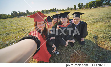 College alumni take selfies in the meadow. College alumni take selfies in the meadow. 113702063