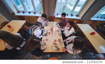 Children eating in the school cafeteria. Children eating in the school cafeteria. 113702134