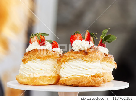 Yolk wreaths with cream and strawberries, closeup. 113702195
