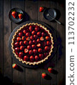 Scrumptious strawberry tart on dark wooden background with fresh strawberries scattered and shadow play, aesthetic food photography, generated with AI. 113702232