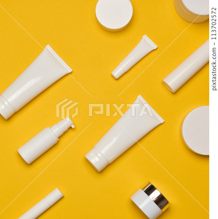 Various types of white plastic packaging, bottle, jar, tube on a yellow background. Various types of white plastic packaging, bottle, jar, tube on a yellow background. 113702572