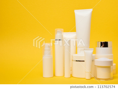 Various types of white plastic packaging, bottle, jar, tube on a yellow background. Container for cosmetics Various types of white plastic packaging, bottle, jar, tube on a yellow background. Container for cosmetics 113702574