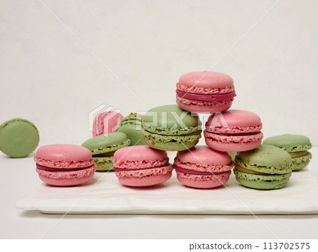 Raspberry and pistachio macarons on a white background Raspberry and pistachio macarons on a white background 113702575