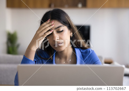 Exhausted young Indian freelancer woman with closed eyes at laptop Exhausted young Indian freelancer woman with closed eyes at laptop 113702667