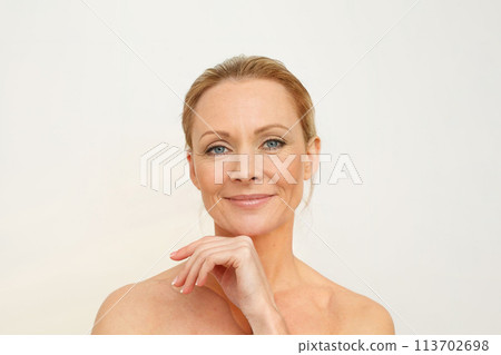 Mature adult woman with healthy aged skin, wrinkles and cute smile isolated on white studio  113702698