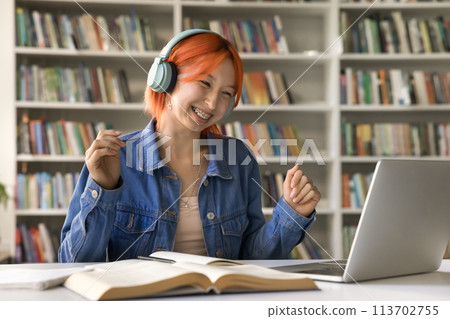 Laughing girl with headphones watching webinar, listening music or e-learning Laughing girl with headphones watching webinar, listening music or e-learning 113702755