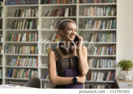Smiling girl enjoy pleasant talk on smartphone during school break Smiling girl enjoy pleasant talk on smartphone during school break 113702982