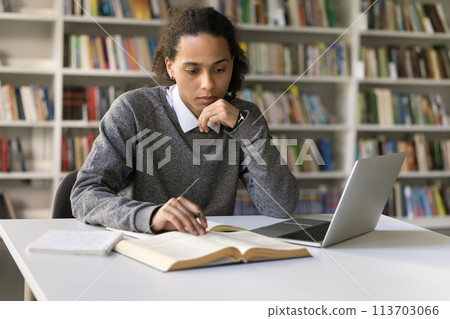 Latin guy student reads paragraph, learns topic, studying in library Latin guy student reads paragraph, learns topic, studying in library 113703066