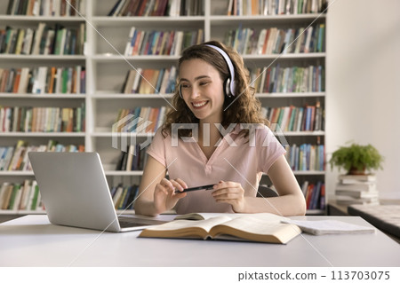 Happy girl in headphones engaged in on-line class 113703075