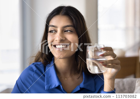 Cheerful beautiful young Indian woman promoting healthy aqua balance Cheerful beautiful young Indian woman promoting healthy aqua balance 113703082