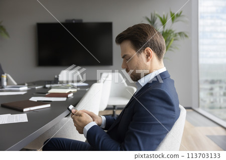 Serious businessman type business message use smartphone Serious businessman type business message use smartphone 113703133