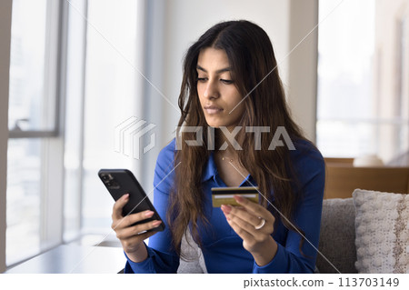 Young Indian bank customer woman inserting credit card data Young Indian bank customer woman inserting credit card data 113703149