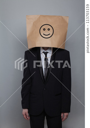 Anonymous businessman hiding his head behind happy smile emoticon on gray background 113703159