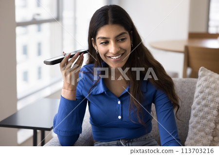 Cheerful young Indian woman holding smartphone at ear 113703216