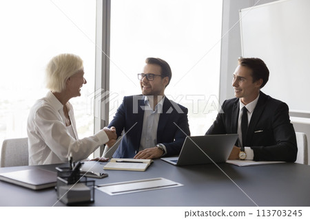 Older 50s businesslady make deal, shake hands company representative Older 50s businesslady make deal, shake hands company representative 113703245