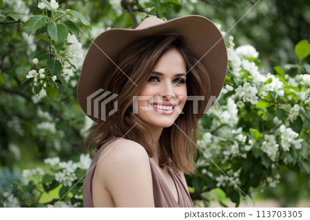 Charming female model with makeup, clean skin, healthy hairstyle and friendly smile in blossom park. Charming female model with makeup, clean skin, healthy hairstyle and friendly smile in blossom park. 113703305